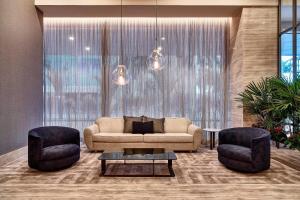 a living room with a couch and two chairs at Sheraton Santos Hotel in Santos