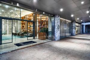 a lobby of a building with glass windows and a couch at Sheraton Santos Hotel in Santos