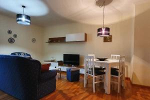 a living room with a couch and a table with chairs at Apartamento playa Llas in Foz