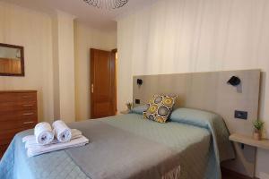 a bedroom with a bed with towels on it at Apartamento playa Llas in Foz