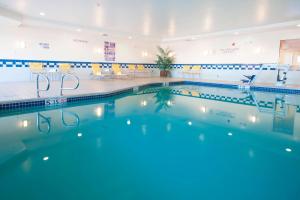 a swimming pool in a building with chairs and tables at Fairfield Inn & Suites El Centro in El Centro