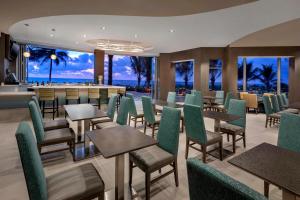 een restaurant met tafels en stoelen en een bar bij Residence Inn Fort Lauderdale Pompano Beach/Oceanfront in Pompano Beach