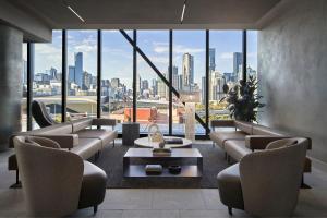 a living room with couches and a view of a city at AC Hotel by Marriott Melbourne Southbank in Melbourne