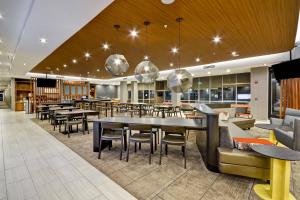 a restaurant with tables and chairs in a cafeteria at SpringHill Suites by Marriott Cincinnati Blue Ash in Blue Ash