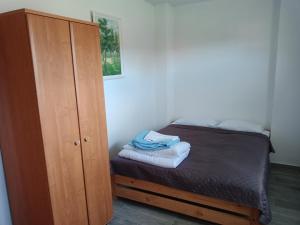 a small bedroom with a bed and a cabinet at U Anny i Piotra in Mielenko
