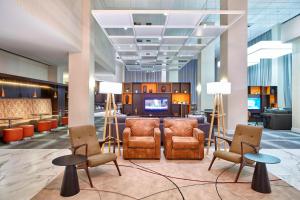 a lobby with chairs and a television in a building at Residence Inn by Marriott Rio de Janeiro Barra da Tijuca in Rio de Janeiro