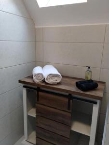 a bathroom with two towels on a wooden shelf at The Garden Apartment in Enniskillen