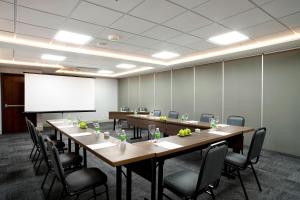 uma sala de conferências com uma mesa e cadeiras e um quadro branco em Residence Inn by Marriott Rio de Janeiro Barra da Tijuca no Rio de Janeiro