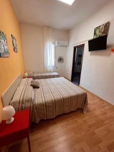 a bedroom with two beds and a red chair at Da Jaco in Castellammare del Golfo
