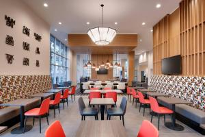 a restaurant with tables and chairs and a tv at TownePlace Suites by Marriott Salt Lake City Downtown in Salt Lake City