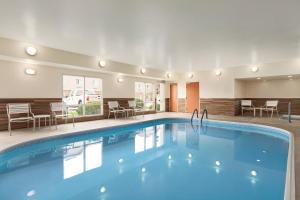 a pool in a hotel room with chairs and tables at Fairfield Inn & Suites Omaha East/Council Bluffs, IA in Council Bluffs