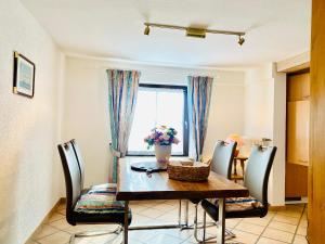 ein Esszimmer mit Tisch und Stühlen und einem Fenster in der Unterkunft Barbarahof Ferienwohnung Vita Erdgeschoss in Markdorf