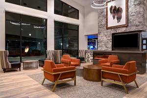 vestíbulo con chimenea, TV y sillas en Residence Inn by Marriott Steamboat Springs, en Steamboat Springs