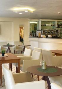 a restaurant with tables and chairs and a counter at Hotel Little in Rimini