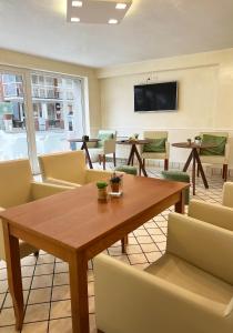Hotel Little في ريميني: قاعة اجتماعات مع طاولة وكراسي خشبية