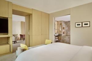 a bedroom with a large white bed and a bathroom at The Ritz-Carlton, Wolfsburg in Wolfsburg