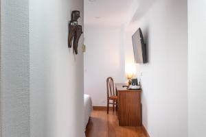 einen Flur mit einem Zimmer mit einem Schreibtisch und einem TV in der Unterkunft Hotel A.S. Sao Joao da Madeira in São João da Madeira