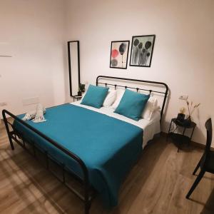 a bedroom with a bed with a blue blanket at Eat&Stay B&B in Pompei