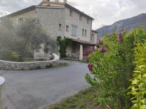 a large stone building with a table and flowers at Studio massacan in Entrevaux