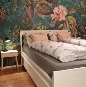 a bed in a bedroom with a floral wallpaper at Waldhaus Dötlingen Ferienhaus im Naturpark in Dötlingen