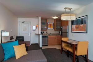 a living room with a table and a kitchen at Residence Inn Bryan College Station in College Station