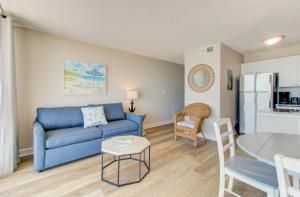 a living room with a blue couch and a table at 1010 Relax, Unwind, Enjoy by Atlantic Towers in Carolina Beach