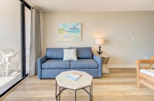 1010 Relax, Unwind, Enjoy by Atlantic Towers في كارولينا بيتش: غرفة معيشة مع أريكة زرقاء وطاولة