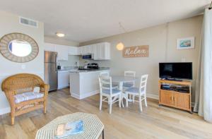 a kitchen and living room with a table and chairs at 1010 Relax, Unwind, Enjoy by Atlantic Towers in Carolina Beach