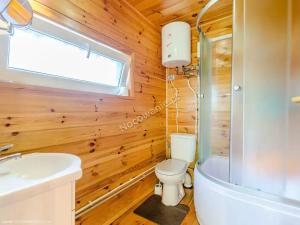 a wooden bathroom with a toilet and a sink at Domki na Chabrowej in Augustów