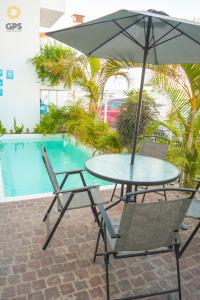 a table and chairs with an umbrella next to a pool at Hotel boutique 402 in Mazatlán