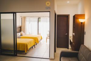 a hotel room with two beds and a couch at Hotel boutique 402 in Mazatlán