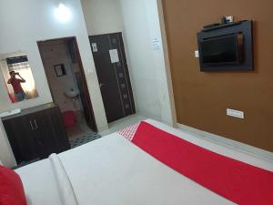 um quarto com uma cama e uma televisão na parede em Flagship Om Gulmohar Avenue em Bhopal