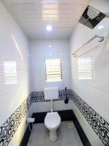 a bathroom with a white toilet in a room at Sukhakarta Holiday Home in Veshvi