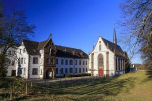 a large white building with a church with a steeple at FeWo-Am-Nationalpark-Eifel in Nideggen