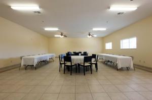 a room with tables and chairs with white table cloths at Guest Inn San Benito/Harlingen in San Benito
