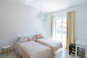 アファンドウにあるFotis House 2の白いベッドルーム(ベッド2台、窓付) +5枚の写真