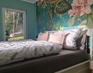 a bedroom with a bed with a floral wallpaper at Waldhaus Dötlingen Ferienhaus im Naturpark in Dötlingen