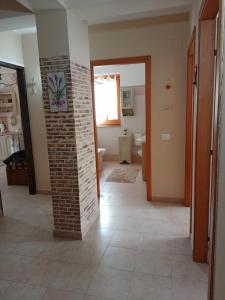 un pasillo con un pilar de ladrillo en una casa en Belvedere Apartment en SantʼAlfio