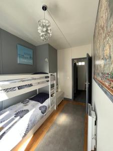 迪耶普的住宿－Le Gîte du Petit Buccin à 2 mn de la mer.，卧室配有白色双层床和吊灯。