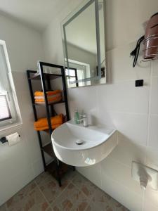 a bathroom with a white sink and a mirror at Ferienwohnung Levin in Dargun +16 photos