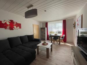 a living room with a black couch and a table at Ferienwohnung Levin in Dargun
