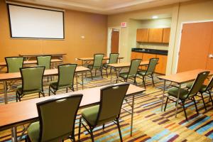 a conference room with tables and chairs and a whiteboard at Fairfield Inn and Suites by Marriott Bartlesville in Bartlesville