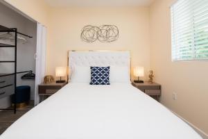 a bedroom with a large white bed with two lamps at Private, Charming 2BR/2.5BA House with Outdoor Patio in Los Angeles