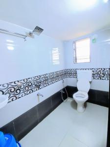 Sukhakarta Holiday Home في Veshvi: حمام مع مرحاض ومغسلة