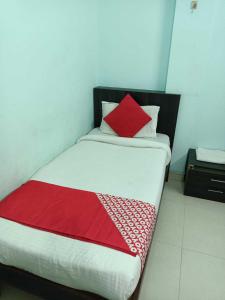 um quarto com uma cama com um cobertor vermelho em Flagship Om Gulmohar Avenue em Bhopal