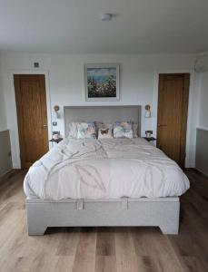 a bedroom with a large bed with two cats on it at Cotts Cabin - Welcombe - 2 min walk to pub in Bideford