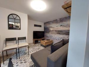 a living room with a couch and a tv at Le Cantou de Juliette (studio) in Prugnanes