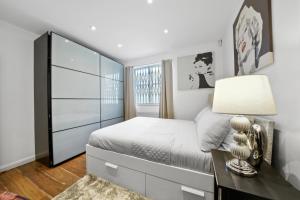 1 dormitorio con 1 cama y escritorio con lámpara en Modern 2Bed Apartment London Cutty Sark O2 Arena Greenwich - Perfect for long stays, en Londres