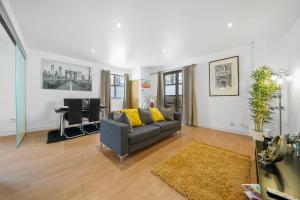 ein Wohnzimmer mit einem Sofa und einem Schreibtisch in der Unterkunft Modern 2Bed Apartment London Cutty Sark O2 Arena Greenwich - Perfect for long stays in London