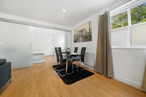ein Wohnzimmer mit einem Tisch und Stühlen in der Unterkunft Modern 2Bed Apartment London Cutty Sark O2 Arena Greenwich - Perfect for long stays in London